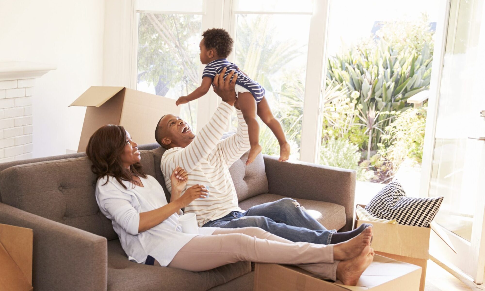 Parents Take A Break On Sofa With Son On Moving Day