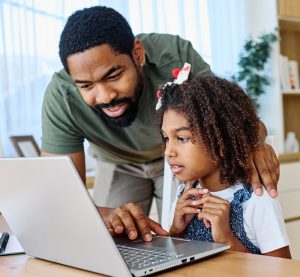 A father helps his daughter with her homework