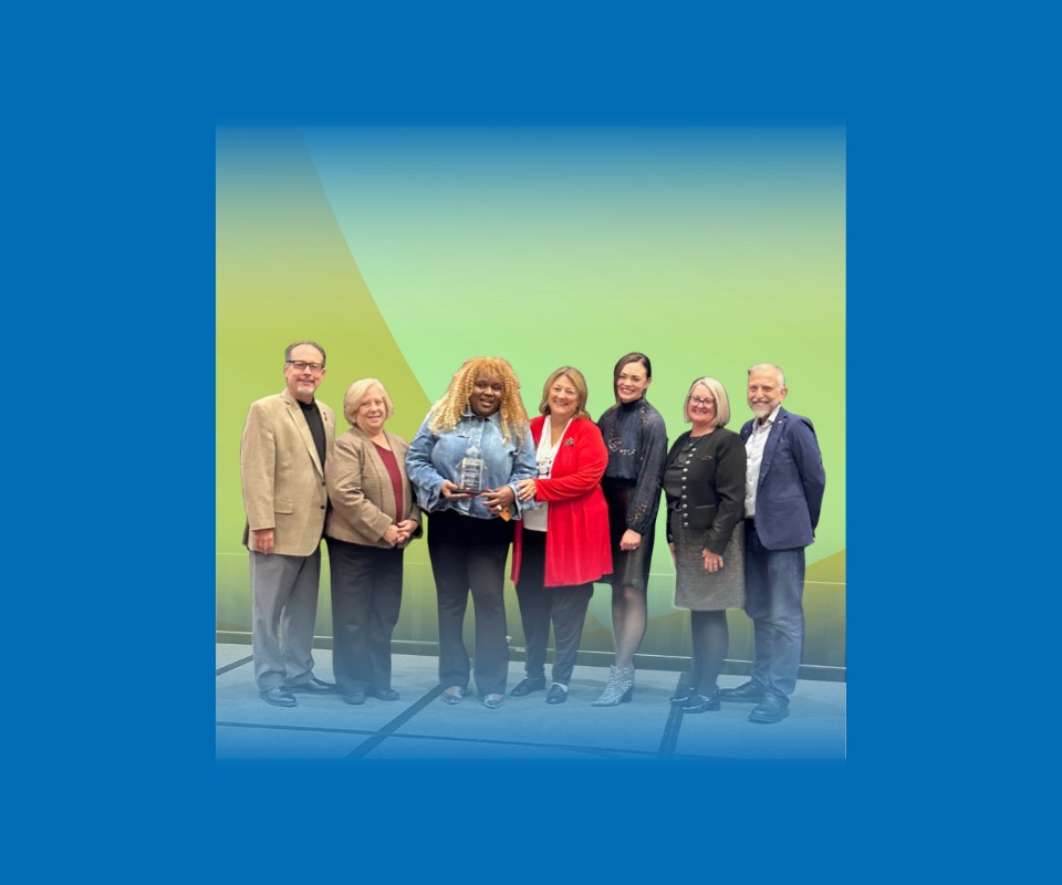 a group of people pose with an award